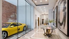 a yellow sports car is parked in front of a glass walled entryway to a modern home