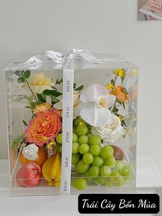 two clear boxes with flowers and fruit in them