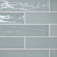 a close up view of a gray tile wall with white grouting on it