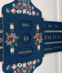 a blue sign with flowers and numbers on it