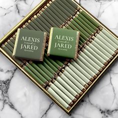 two green books sitting on top of a marble counter next to each other in front of a mirror