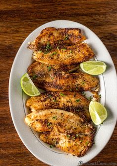 grilled chicken with lime wedges on a white plate