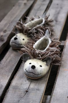 two stuffed animals are sitting on wooden planks with slippers made to look like them