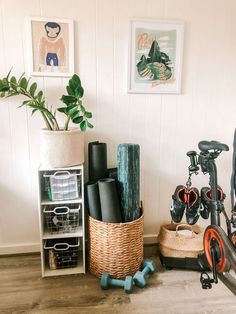 there is a bike and some other things in the room with pictures on the wall