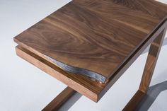 a close up of a wooden table on a white surface with a metal strip at the top