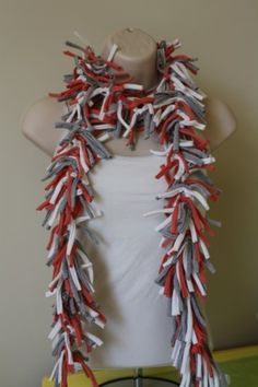 a woman wearing a red, white and grey scarf on top of a mannequin