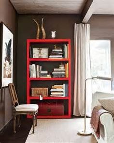 a red bookcase in the corner of a bedroom