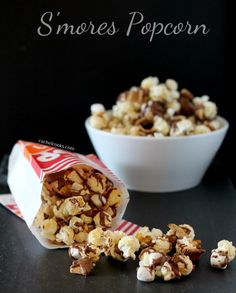 a bowl of chocolate popcorn next to a bag of caramel popcorn on a table