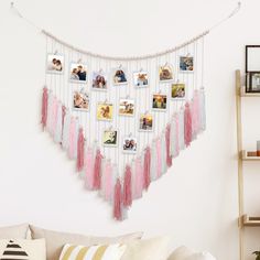 a wall hanging with pictures and tassels in the shape of a heart on it