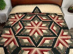 a bed with a quilt on top of it next to a nightstand and potted plant