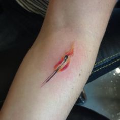 a small tattoo on the arm of a person with an orange and black knife in it