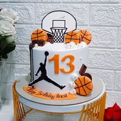 a birthday cake decorated with basketballs and the number thirteen on it's side