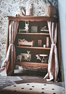 an old book is open to show the inside of a bookshelf with curtains on it