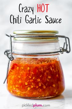 a jar filled with chili sauce sitting on top of a table