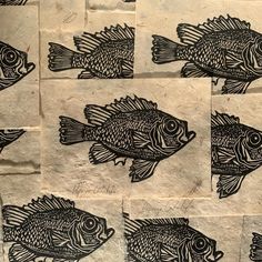 several black and white fish are drawn on some brown paper with holes in the middle