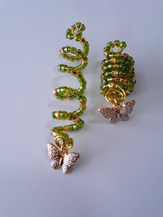 Beaded loc coil made with 4mm green and gold glass seed beads, and gold butterfly charm on brass coil. Fits small to medium locs or braids, hole size 7 to 9mm. Sold individually. Butterfly Locs Accessories, Loc Charms Dreadlock Accessories, Loc Decoration, Loc Jewelry On Short Locs, Locs With Shells, Locs With Accessories, Box Braids Jewelry, Short Locs With Beads, Hair Charms For Braids