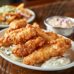 fried fish and coleslaw on a white plate with ranch dressing in the background