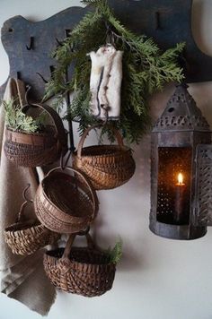 some baskets are hanging on the wall with a candle