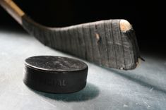 an old hockey puck sitting on top of a metal table next to a hockey stick