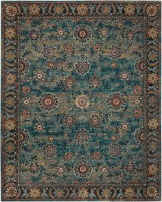 a blue rug with an ornate design on the center and sides, in various colors