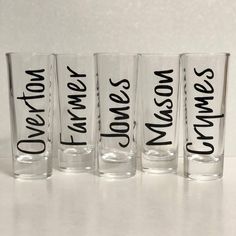 four shot glasses with words on them sitting next to each other