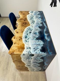 the table is made out of wood and has an ocean scene painted on it, along with blue chairs