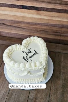 a heart shaped cake on a plate with the words just married written in black ink