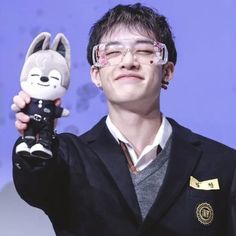 a man holding up a stuffed animal in his hand