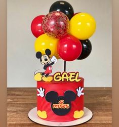 a mickey mouse cake with balloons on top