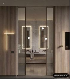 a modern bathroom with mirrors and lights on the wall, along with an open door