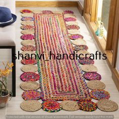 a colorful rug is on the floor next to a potted plant