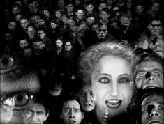 a woman is surrounded by many people in black and white