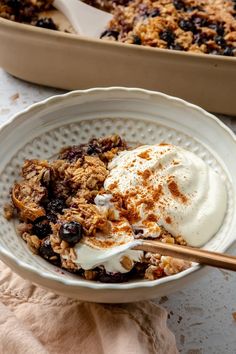 a bowl filled with granola and yogurt next to a baking dish on a table