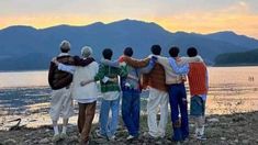 a group of people standing next to each other near the water