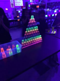 glow in the dark plastic cups are stacked on top of each other with neon colors