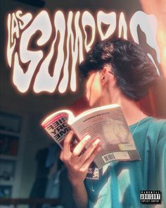 a man reading a book in front of a neon sign