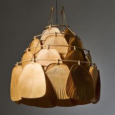 a wooden chandelier hanging from the ceiling with five large fan shaped lamps attached to it