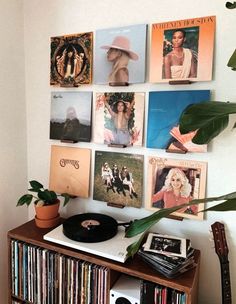 a record player sitting on top of a wooden shelf next to a wall filled with records