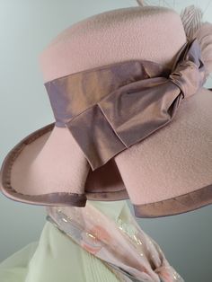 You'll look great in this pretty pink wool felt hat! It can easily transition from Winter to early Spring and is perfect for any dressy occasion. Imagine walking into church with this beauty! The flattering asymmetrical wide brim hat turns up on the left and slopes down on the right. A unique folded pleat adorns the brim. It's topped with a gorgeous mauve/pink band and bow. This hat that will be the envy of everyone who see it! The hat itself is pink wool felt and the crown (top) is slightly dom Pink Wide Brim Felt Hat For Spring, Pink Felt Hat With Short Brim For Spring, Pink Fedora For Kentucky Derby, Pink Fedora Felt Hat For Kentucky Derby, Fitted Pink Brimmed Felt Hat, Pink Brimmed Felt Hat, Pink Fitted Brimmed Felt Hat, Pink Curved Brim Felt Hat For Kentucky Derby, Pink Felt Hat With Curved Brim For Kentucky Derby