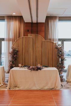 a table is set up with flowers and greenery on it for a wedding reception