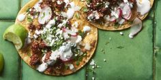 two tacos sitting on top of a green tile floor