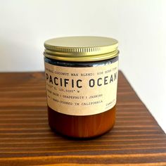 a glass jar filled with brown liquid sitting on top of a wooden table