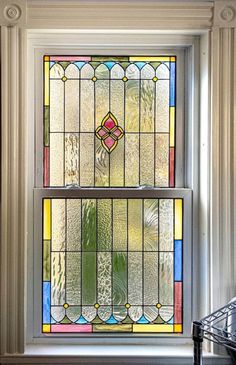 two stained glass windows sitting on top of a window sill