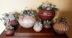 several decorative vases are sitting on top of a wooden table, decorated with bows and ribbons