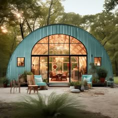 a blue metal building sitting in the middle of a forest