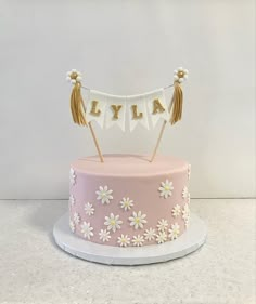 a cake decorated with daisies and bunting banner