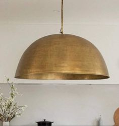 a large brass dome light hanging over a kitchen counter