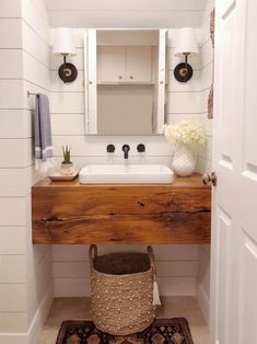 the bathroom is decorated in white and has wood countertop, sink, and mirror