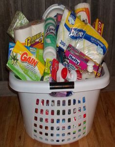 a white basket filled with lots of different types of food and snacks on top of a wooden floor