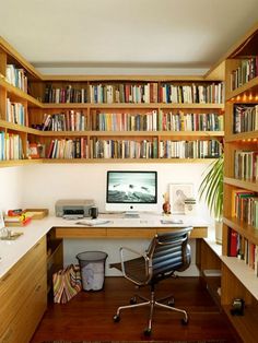 a home office with lots of bookshelves and a computer on the desk in front of it